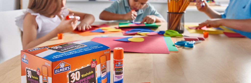 three school aged kids using elmers glue for arts and crafts