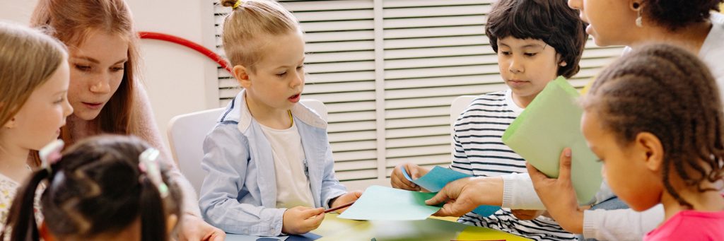 students and a teacher sitting around a table doing a bonding activity
