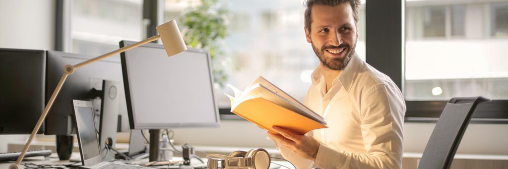 man at his desk with book