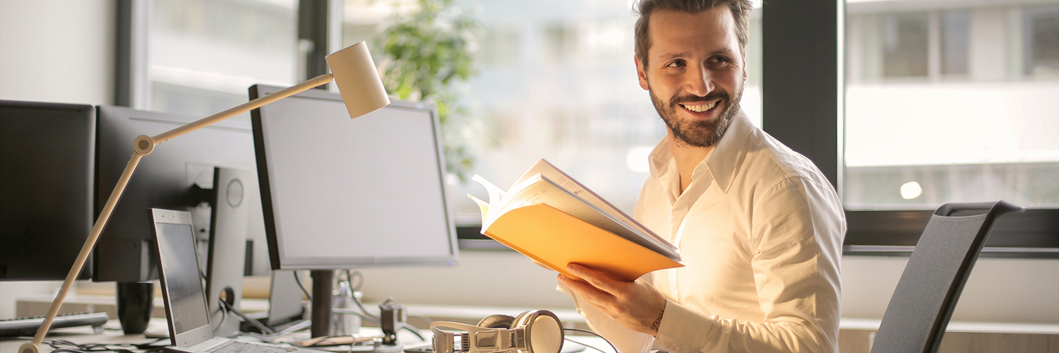 man at his desk with book