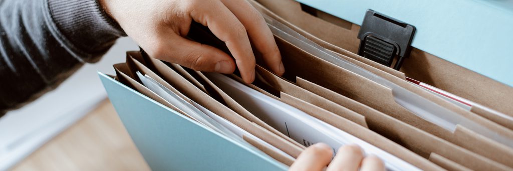 person picking out document from folder