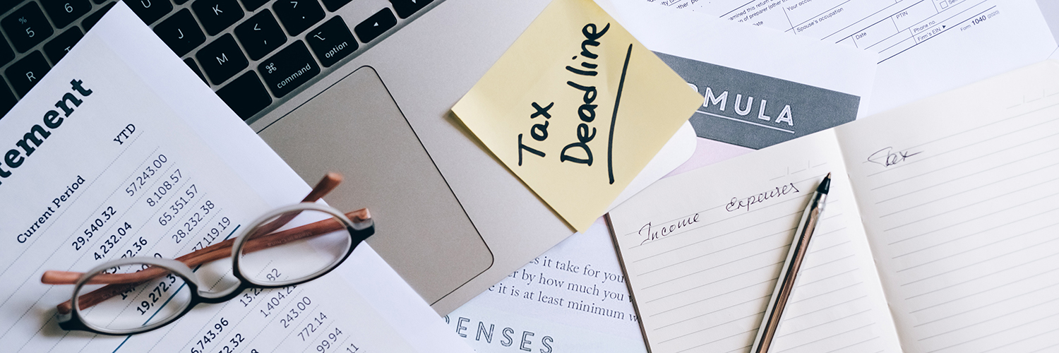 computer with tax papers and notes