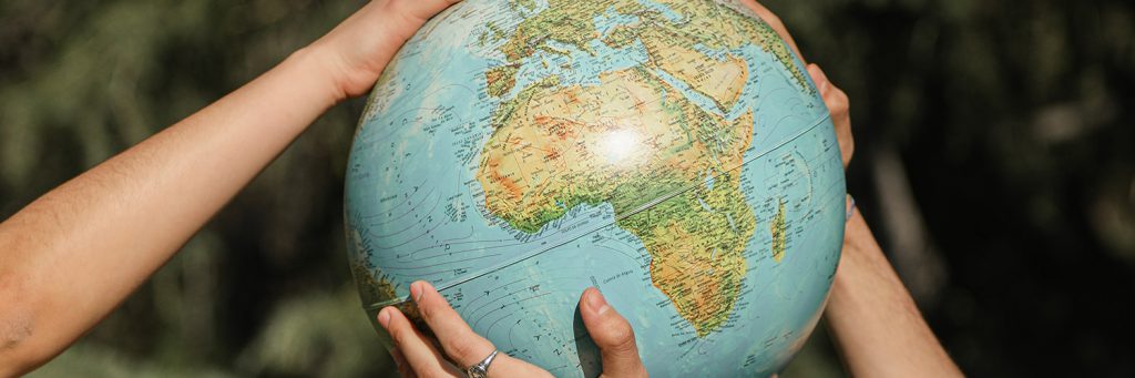 two people holding globe