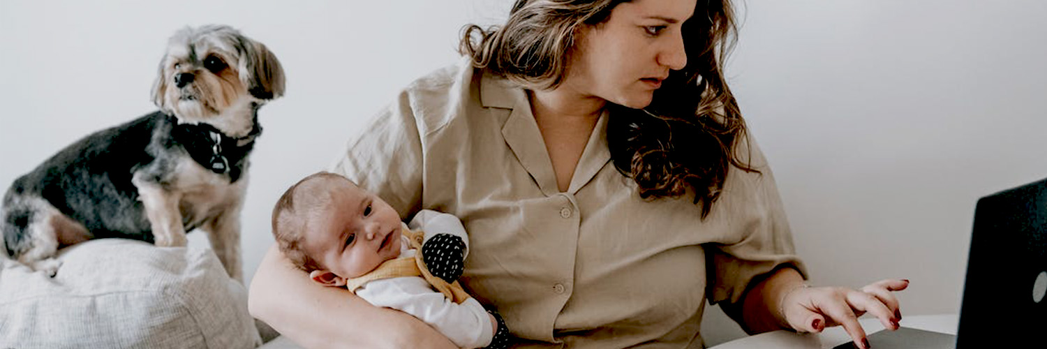 Mom holding baby while working