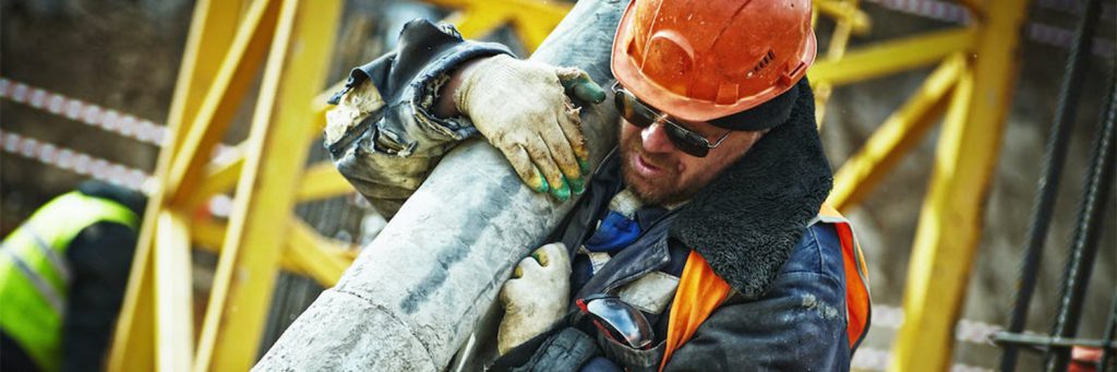 Construction-worker-holding-pipe-bundled-up
