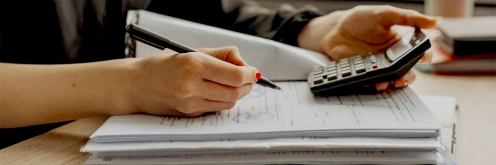 Woman doing taxes holding calculator