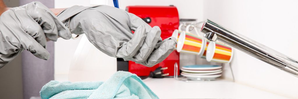 someone taking off gloves at the sink