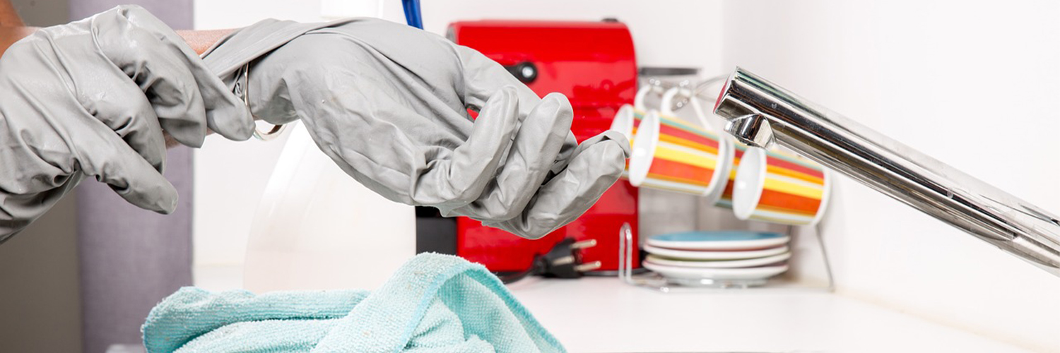 someone taking off gloves at the sink
