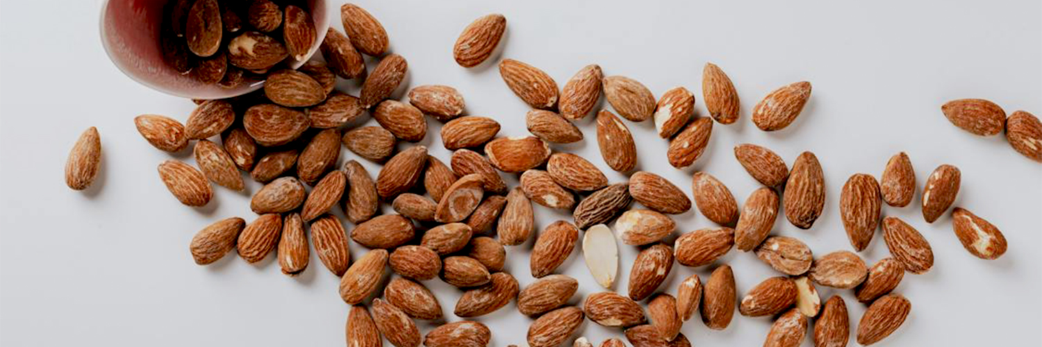 Bowl of almonds spilled onto table