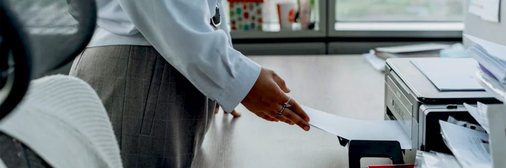 woman pulling paper from printer