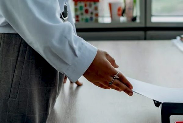 woman pulling paper from printer