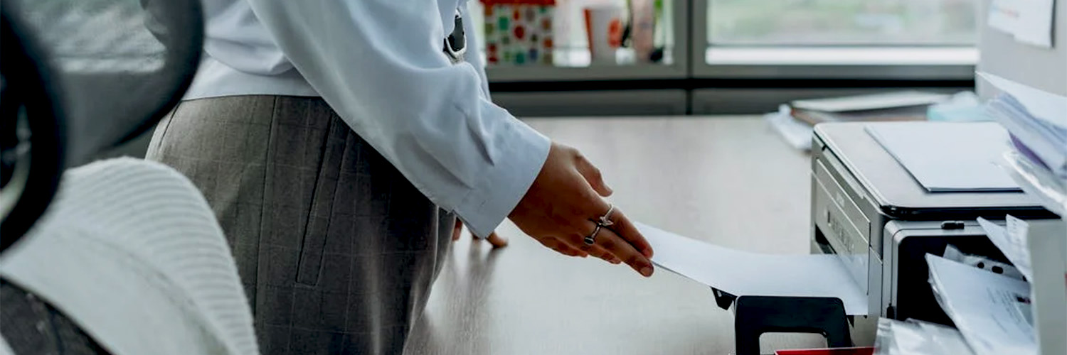 woman pulling paper from printer