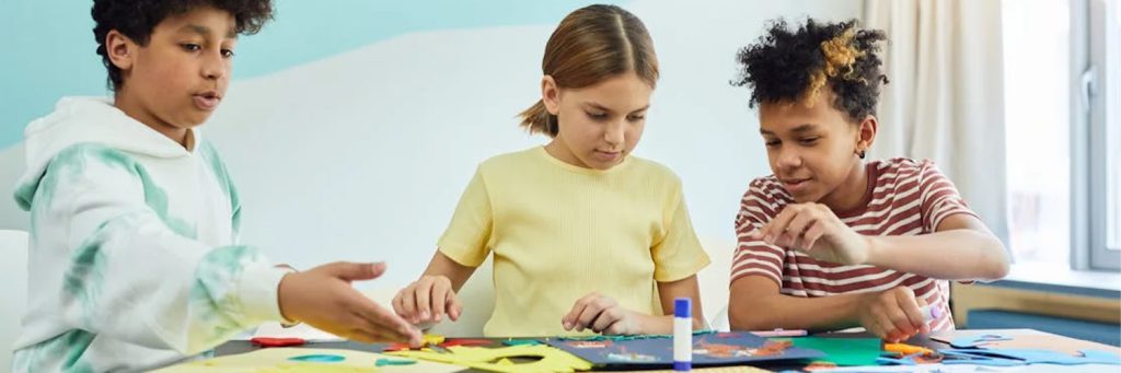 three kids using glue sticks