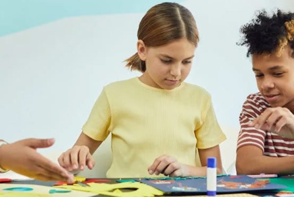 three kids using glue sticks